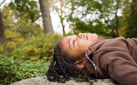 child looking at sky in nature