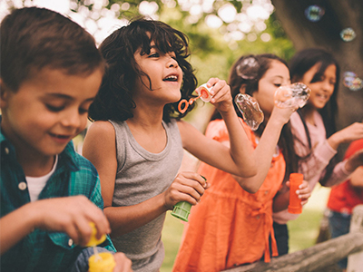 kids outside blowing bubbles