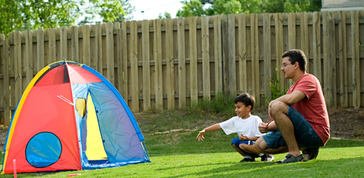 dad and son in backyard looking at tent